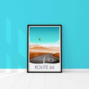 May include: A framed print of a desert landscape with a road leading to a Route 66 sign. The sky is blue and there is a bird flying in the distance. The text "ROUTE 66" is printed below the image.