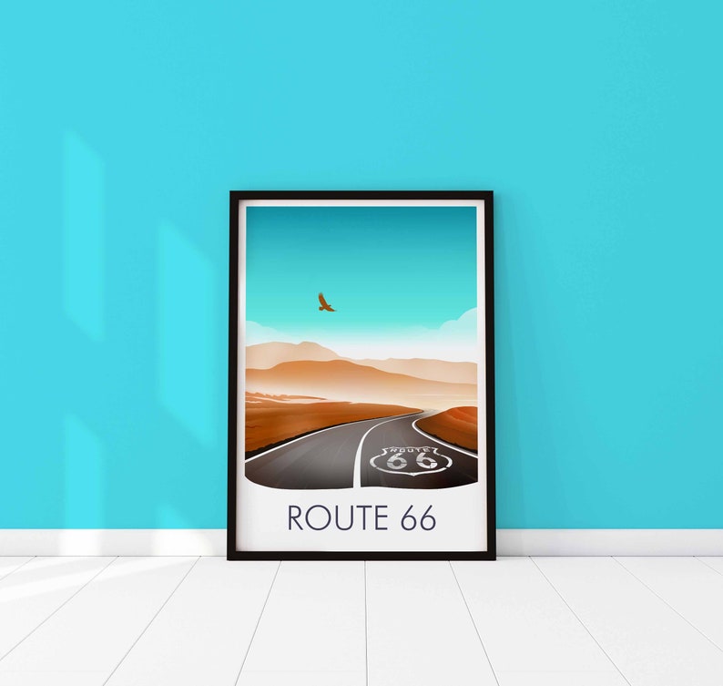 May include: A framed print of a desert landscape with a road leading to a Route 66 sign. The sky is blue and there is a bird flying in the distance. The text "ROUTE 66" is printed below the image.