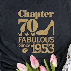 May include: Black t-shirt with gold text that reads "Chapter 70 Fabulous Since 1953". The text is decorated with a high heel shoe, butterflies, and a lipstick kiss.