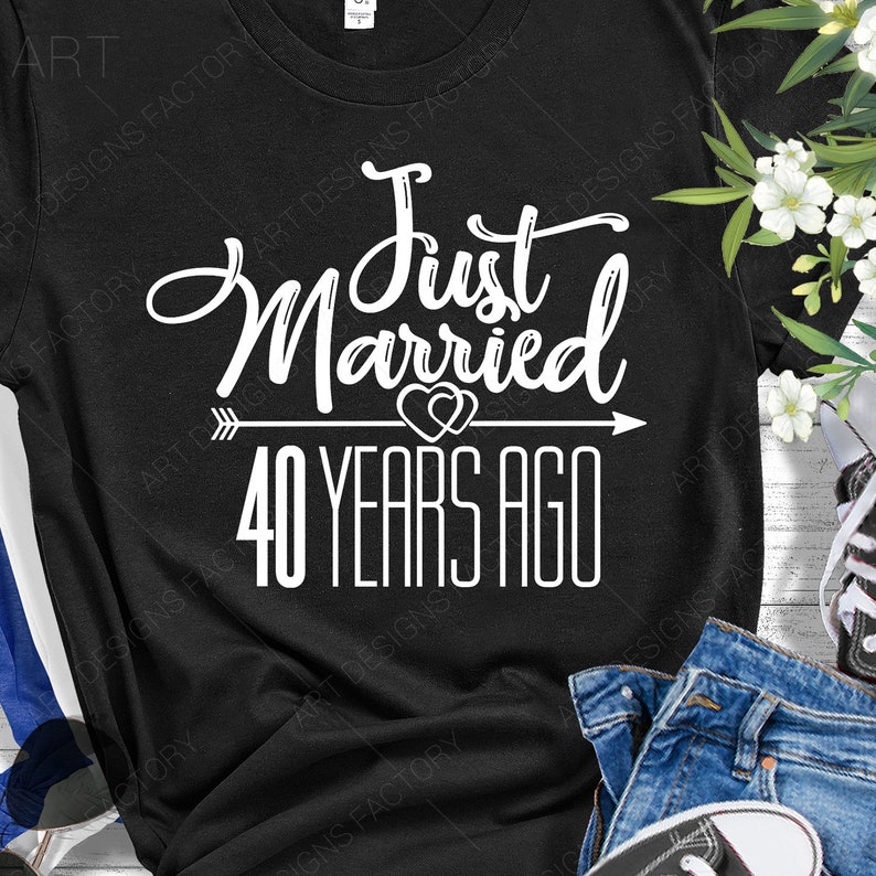 May include: Black t-shirt with white text that reads "Just Married 40 Years Ago" with an arrow and two hearts.