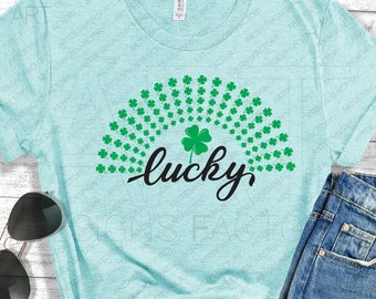 May include: A light blue t-shirt with a green shamrock design and the word "lucky" in black script.