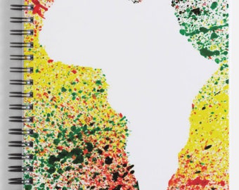 May include: A white notebook with a spiral binding. The cover features a white outline of the continent of Africa against a background of colorful paint splatters in shades of red, yellow, green, and black.