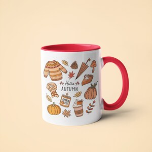 May include: White ceramic mug with a red interior and handle, decorated with autumn-themed illustrations. The design includes a sweater, leaves, pumpkins, and the text "Hello Autumn".