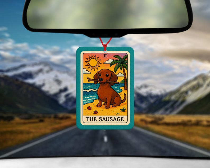 May include: A rectangular air freshener with a teal border, featuring a cartoon dachshund holding a stick on a beach scene. The design includes a sun, palm tree, and the text "THE SAUSAGE". The air freshener hangs from a red string.
