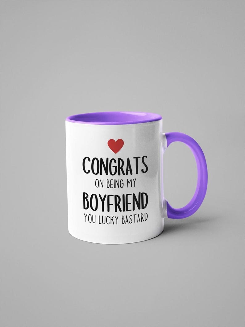 A white and purple mug with text that reads "CONGRATS ON BEING MY BOYFRIEND YOU LUCKY BASTARD" printed on it.
