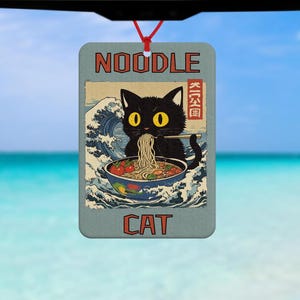 Könnte beinhalten: Eine schwarze Katze mit gelben Augen isst Nudeln aus einer Schüssel. Die Katze sitzt vor einer Welle mit japanischen Schriftzeichen. Der Text "NOODLE CAT" befindet sich oben und unten im Bild.
