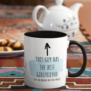 Pode incluir: Caneca de caf&eacute; branca com borda e al&ccedil;a pretas. A caneca tem um fundo de aquarela azul com o texto "Este cara tem a melhor namorada (sim, ela me comprou esta caneca)".