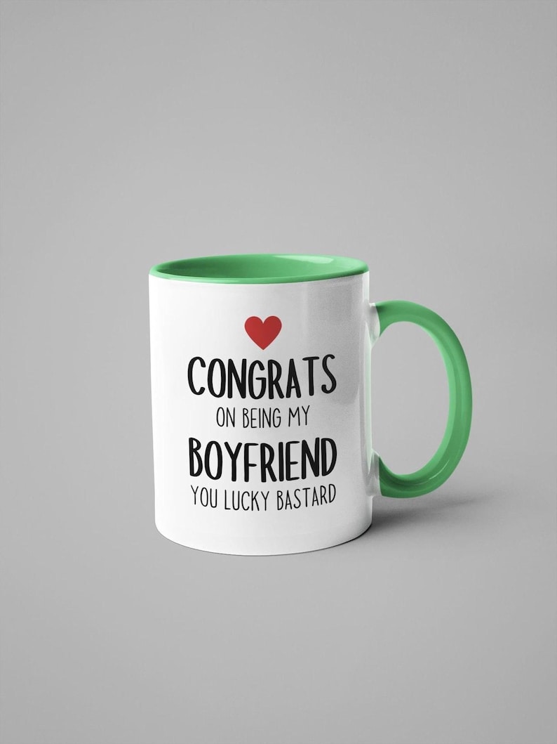 A white and green mug with text printed on it.