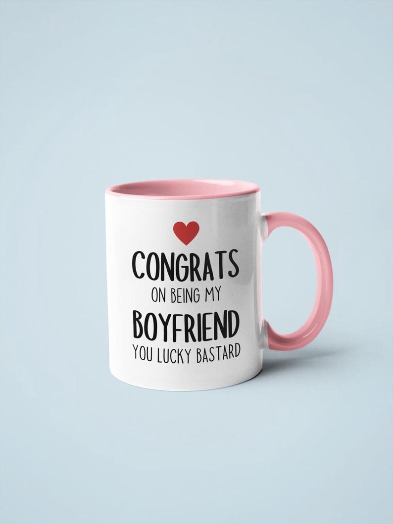 A white and pink mug with text printed on it.