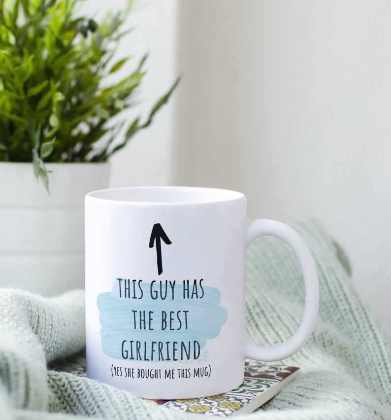 Pode incluir: Caneca de cer&acirc;mica branca com uma seta preta apontando para cima e o texto "Este cara tem a melhor namorada (sim, ela me comprou esta caneca)".