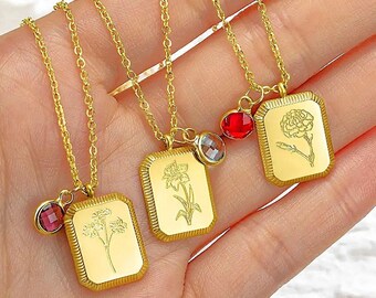 May include: Three gold necklaces with rectangular pendants, each engraved with a floral design. Each necklace has a small, coloured gemstone charm. The chains and pendants are a bright, shiny gold colour.
