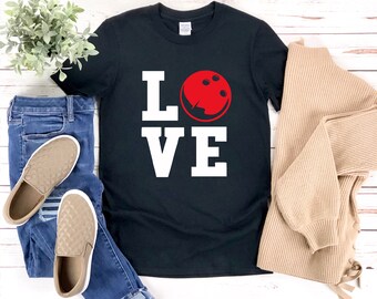 May include: Black t-shirt with white text that reads "LOVE" with a red bowling ball graphic in the "O".