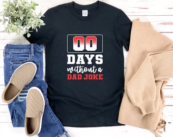 Könnte beinhalten: Schwarzes T-Shirt mit einer weißen Grafik, auf der "00 Tage ohne Papa-Witz" steht. Die Grafik ist ein rot-weißer Countdown-Timer.