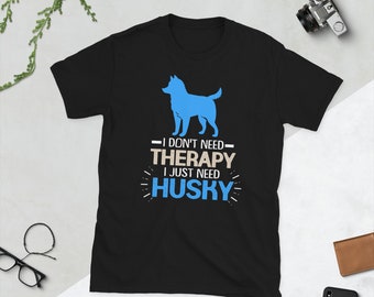 Op de afbeelding: Zwart T-shirt met een blauwe silhouet van een husky-hond en de tekst "Ik heb geen therapie nodig, ik heb alleen een husky nodig".