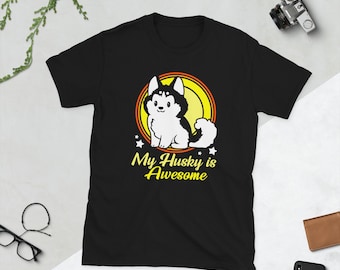 Op de afbeelding: Zwart T-shirt met een cartoon husky-hond in een gele cirkel met de tekst "My Husky is Awesome".