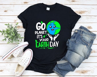 Peut inclure: T-shirt noir avec un dessin de la Terre en cartoon vert et bleu et le texte "Go Planet It's Your Earth Day".
