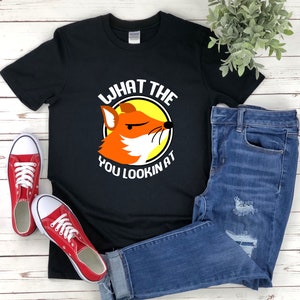 K&ouml;nnte beinhalten: Schwarzes T-Shirt mit einer wei&szlig;en Grafik eines Fuchses mit dem Text "What the you lookin at".