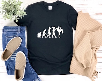 May include: Black t-shirt with a white graphic of the evolution of man, ending with a man doing a martial arts kick. The graphic says "Evolution of a Fighter".