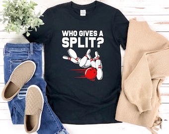 May include: Black t-shirt with a white graphic of bowling pins and a bowling ball. The text "Who gives a split?" is printed in white on the shirt.