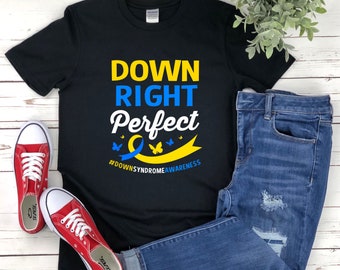 May include: Black t-shirt with the text "Down Right Perfect" in yellow and blue lettering. A yellow and blue ribbon with butterflies is below the text. The hashtag "#downsyndromeawareness" is below the ribbon.