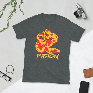 May include: A dark gray t-shirt with a yellow and red python snake illustration and the word "PYTHON" in yellow lettering.