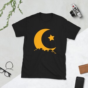 May include: Black t-shirt with a yellow crescent moon and star graphic.