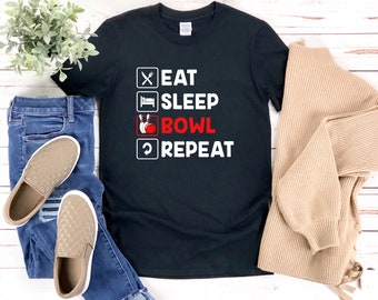 May include: Black t-shirt with white text that reads "Eat Sleep Bowl Repeat" with a bowling pin graphic.
