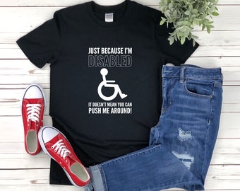May include: Black t-shirt with white text that reads "Just because I'm disabled it doesn't mean you can push me around!" and a white wheelchair symbol.