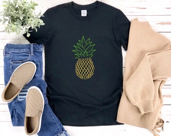 Pode incluir: Camiseta preta com um contorno verde e amarelo de um abacaxi.