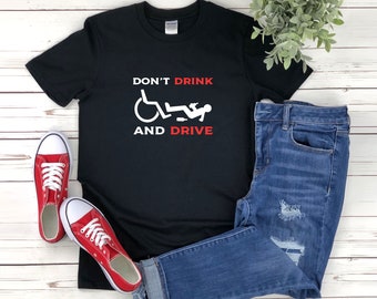 May include: Black t-shirt with a white graphic of a person passed out in a wheelchair with a bottle in their hand. The text "Don't Drink and Drive" is printed in red below the graphic.