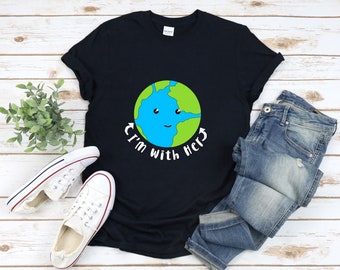 Peut inclure: Un t-shirt noir avec une image de la Terre en dessin animé avec un visage souriant et le texte "I'm with Her" imprimé dessus.