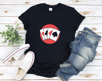 May include: A black t-shirt with a red circle and four playing cards inside. The cards are a spade, a heart, a diamond, and a club.