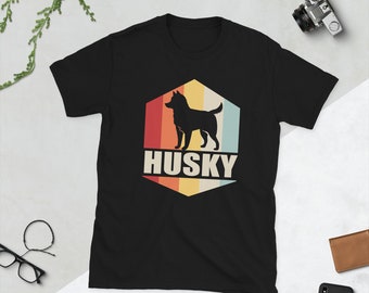 Op de afbeelding: Zwart T-shirt met een retro-grafische afbeelding van een husky-hond in een hexagon met het woord "HUSKY" eronder.
