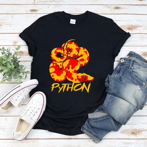 Może przedstawiać: Czarny T-shirt z grafiką przedstawiającą żółto-czerwonego węża pytona z napisem "PYTHON" w kolorze białym poniżej.