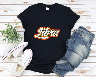Può includere: Maglietta nera con una grafica in stile retrò della parola "Libra" in giallo, rosso e bianco con stelle.