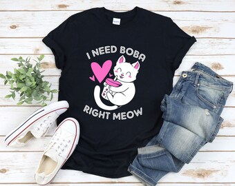 May include: Black t-shirt featuring a white cat drinking boba tea with the text "I need boba right meow".