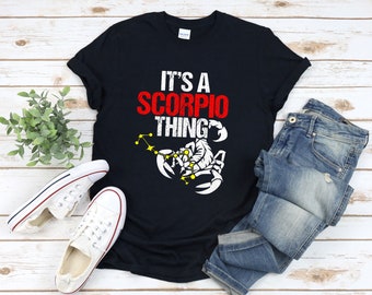 May include: Black t-shirt with white text that reads "It's a Scorpio thing" and a white scorpion graphic with yellow stars.