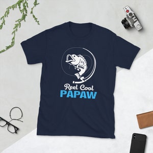 May include: Navy blue t-shirt with a white graphic of a fish on a fishing hook. The text "Reel Cool Papaw" is printed in white and blue.