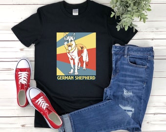 May include: Black t-shirt with a retro-style image of a German Shepherd dog. The image is in shades of red, yellow, blue, and white. The text "GERMAN SHEPHERD" is printed below the image.