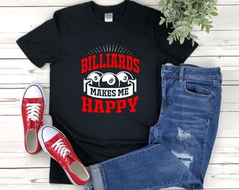 Op de afbeelding: Zwart T-shirt met witte tekst die "Billiards Makes Me Happy" zegt en een afbeelding van drie biljartballen met de nummers 5, 8 en 3. Het shirt wordt gecombineerd met een blauwe jeans en rode sneakers.