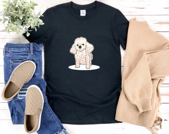 Könnte beinhalten: Schwarzes T-Shirt mit einer Cartoon-Illustration eines weißen Pudels. Der Hund steht auf seinen Hinterbeinen mit erhobenen Vorderpfoten.