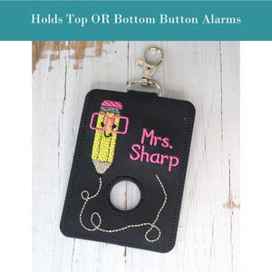 May include: Black fabric key chain with a pencil design and the text "Mrs. Sharp". The key chain has a metal ring and a hole for a button.