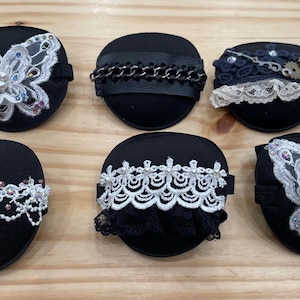 May include: Six black eye patches with different lace and embellishments. The patches feature butterflies, chains, and lace trim.