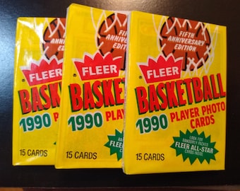 Puede incluir: Tres paquetes sin abrir de cromos de jugadores de baloncesto Fleer de 1990. Los paquetes son amarillos con texto rojo y verde, con el logotipo de Fleer y un gráfico de red de baloncesto. Cada paquete contiene 15 cromos.