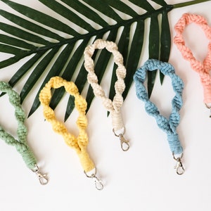 May include: Five colorful, twisted rope keychains with silver key rings. The keychains are in shades of green, yellow, blue, pink, and cream.