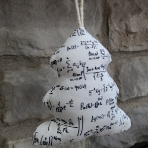 May include: White fabric Christmas tree ornament with black mathematical equations printed on it. The ornament is hanging from a string.