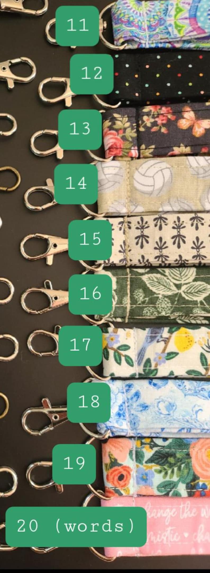 May include: A collection of fabric keychains with various patterns, including floral, polka dots, and volleyball designs. Each keychain has a metal clasp for easy attachment. The keychains are arranged on a dark surface.