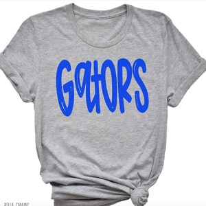 May include: A gray t-shirt with the word "GATORS" printed in blue.