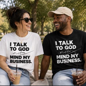 May include: A white t-shirt and a black t-shirt, both featuring the bold black or white text that reads I TALK TO GOD AND MIND MY BUSINESS. The shirts have short sleeves and a crew neckline, displaying a clear graphic print on the front chest area.