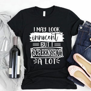 Könnte beinhalten: Schwarzes T-Shirt mit weißem Text, der lautet: "Ich mag unschuldig aussehen, aber ich mache viele Screenshots".